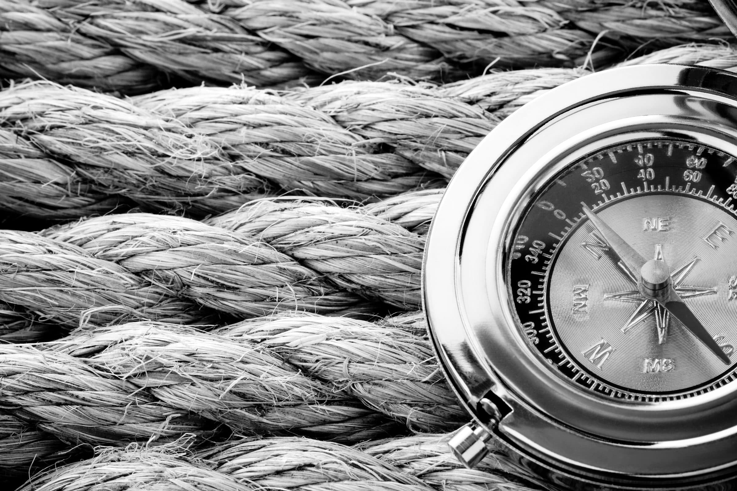 Een kompas op een opgerold scheepstouw
